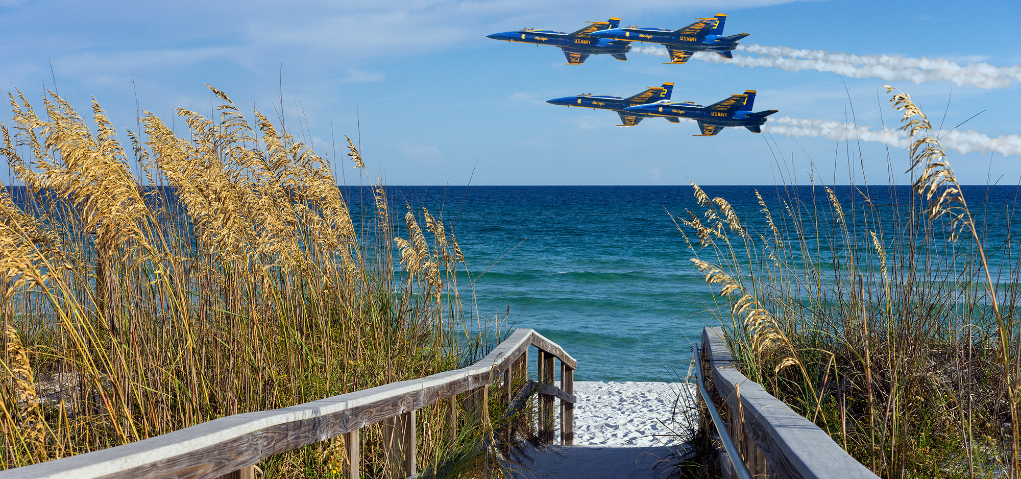 Blue angel planes flying over a beach boardwalk